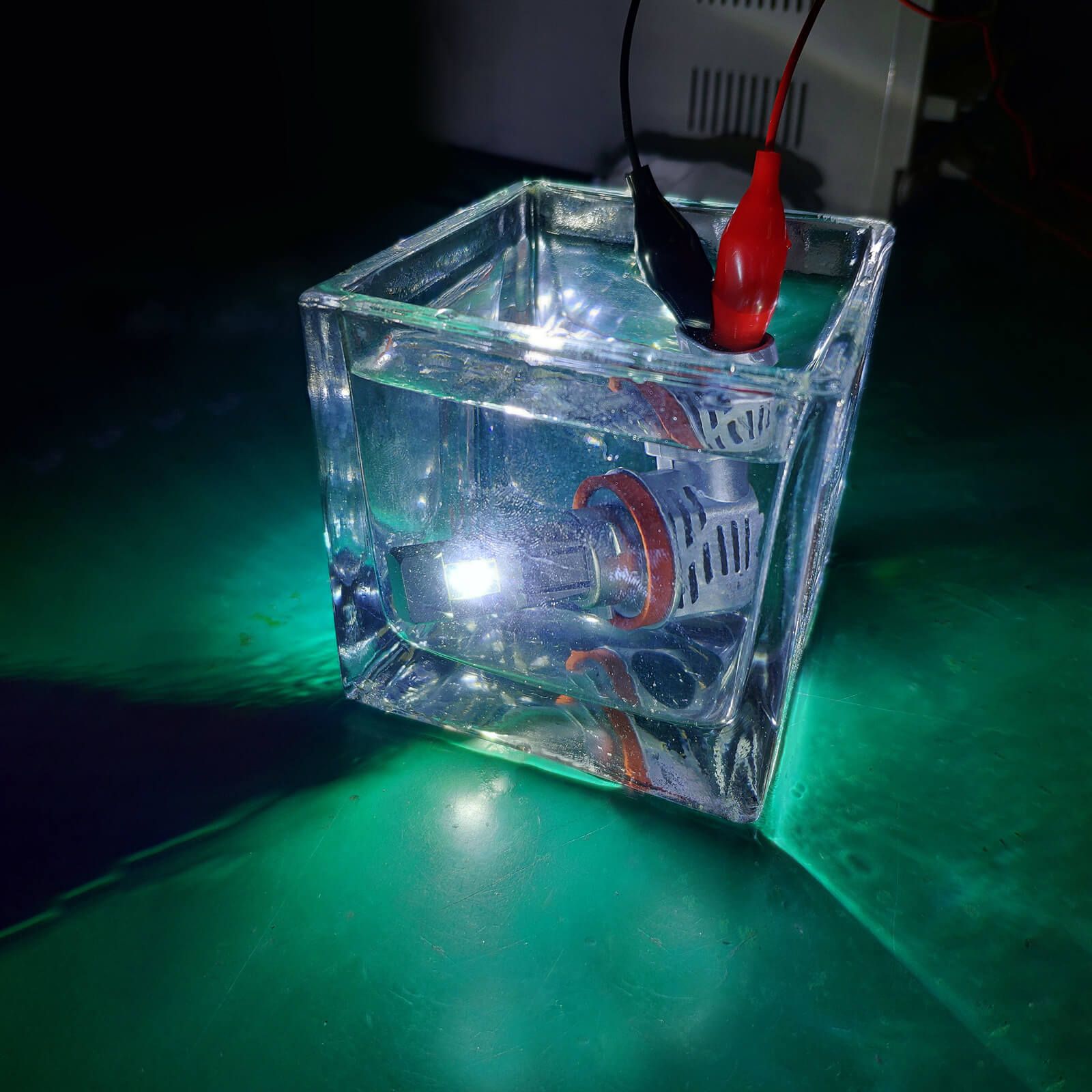 A Surefit LED globe submerged in a glass of water