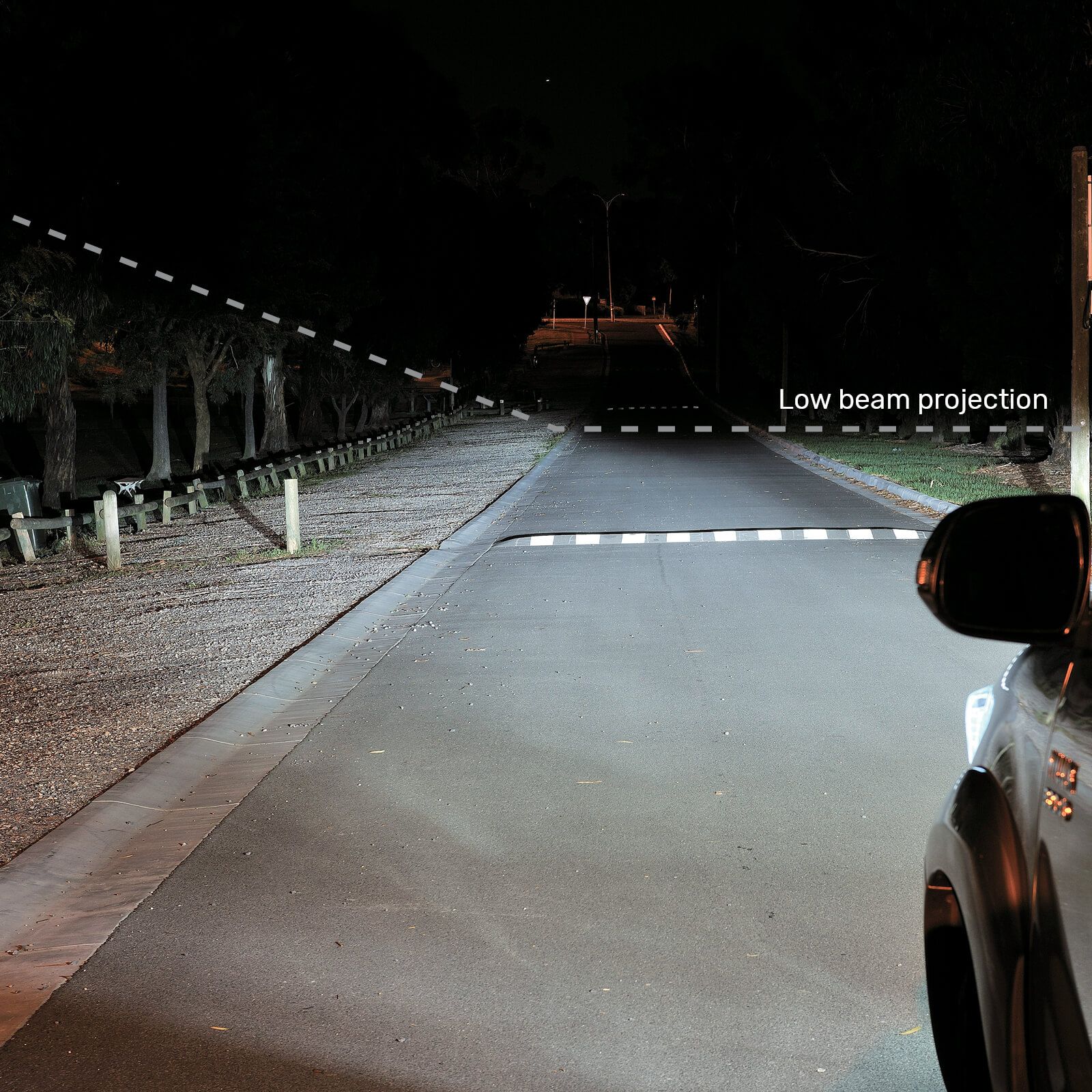 A car shines bright white light onto road from its headlights