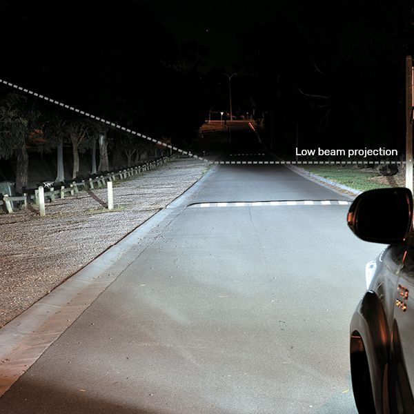 A car shines bright white light onto road from its headlights
